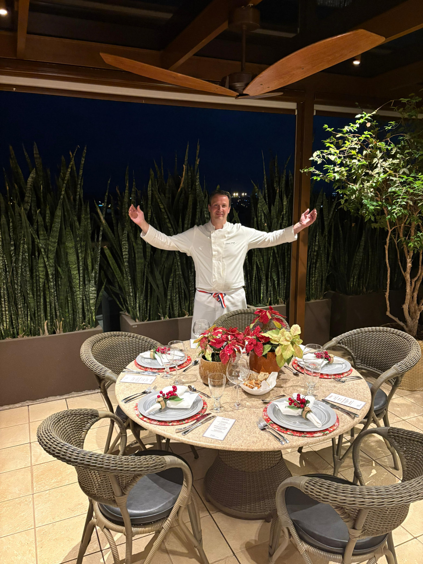 Chef Lionel Ortega ao lado de mesa posta finalizada em serviço privado